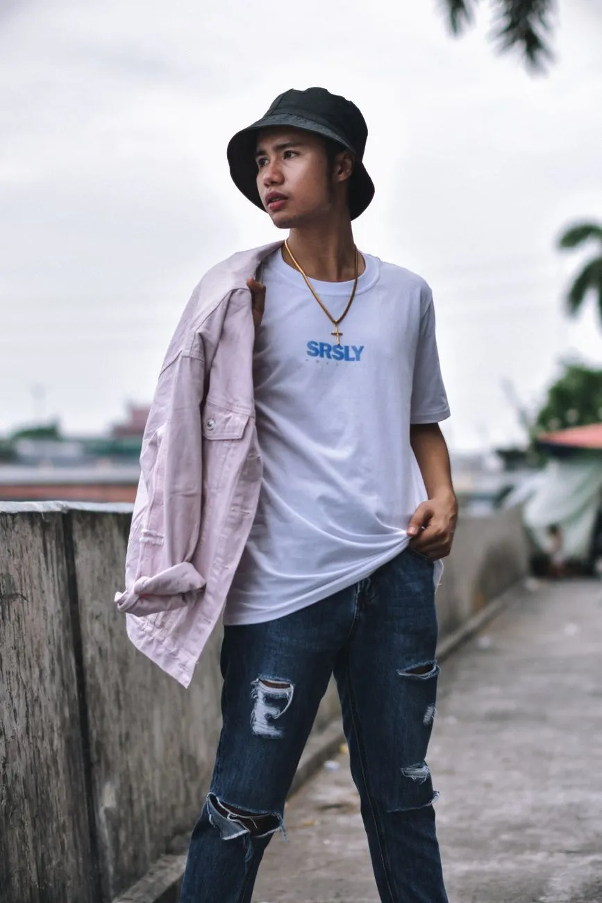 Chàng trai mặc áo thun trắng, quần jeans và khoác áo sơ mi ngoài