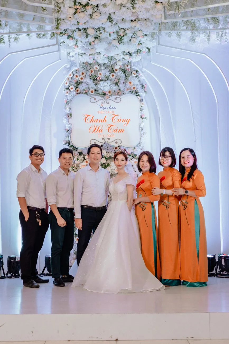 Bride and groom with family at a Vietnamese wedding, men in white shirts and women in ao dai